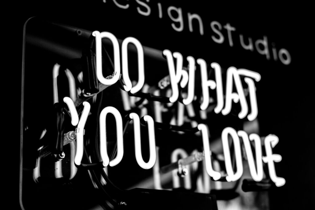 a neon sign in white lettering saying do what you love with a black background