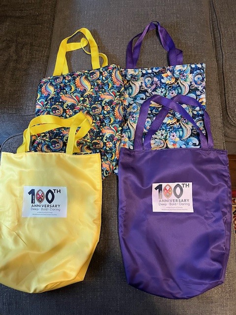 purple and yellow gift bags with 100th anniversary logo